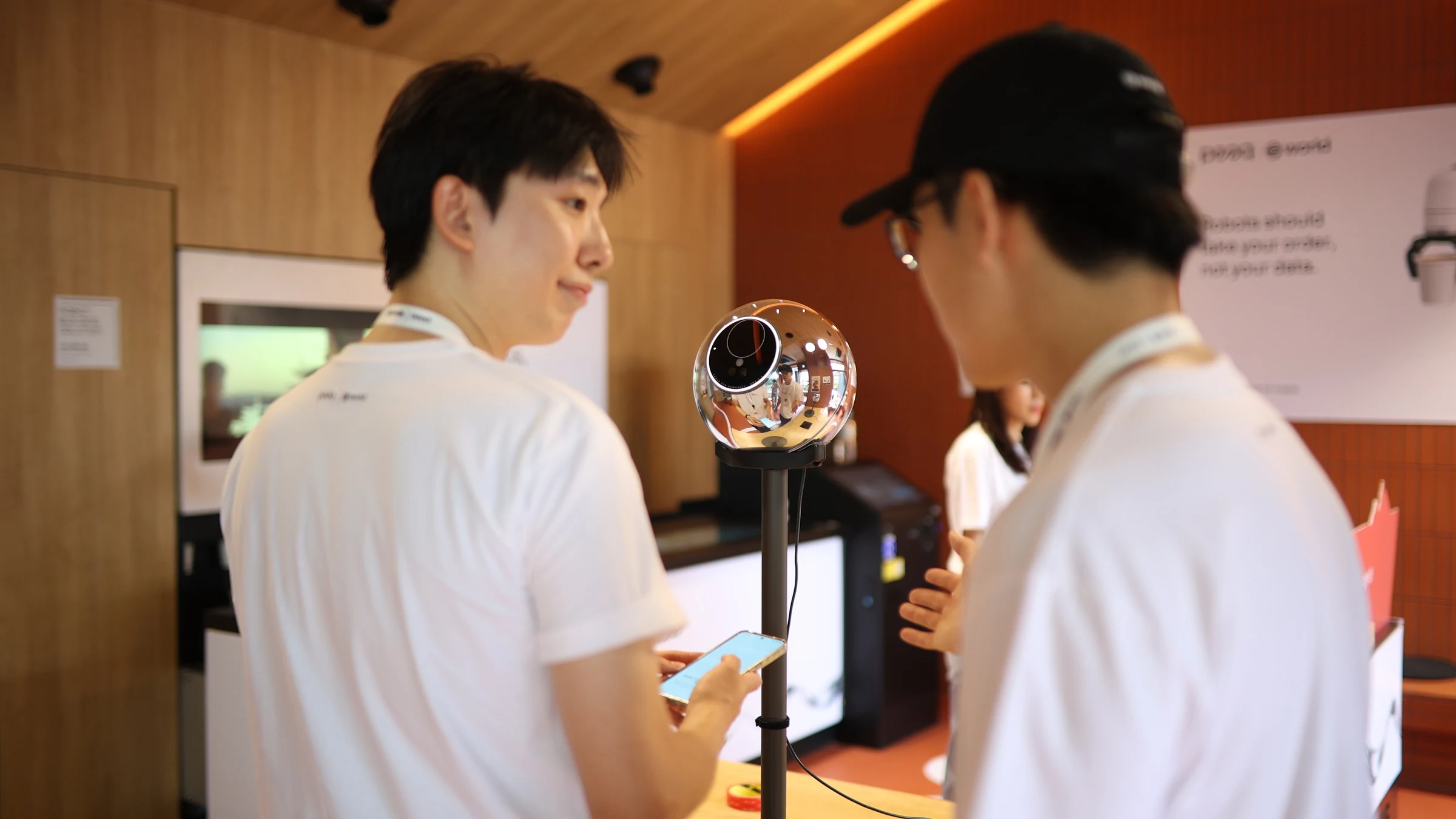 World × peaq — Visitors speaking beside a World Orb, KBW 2026