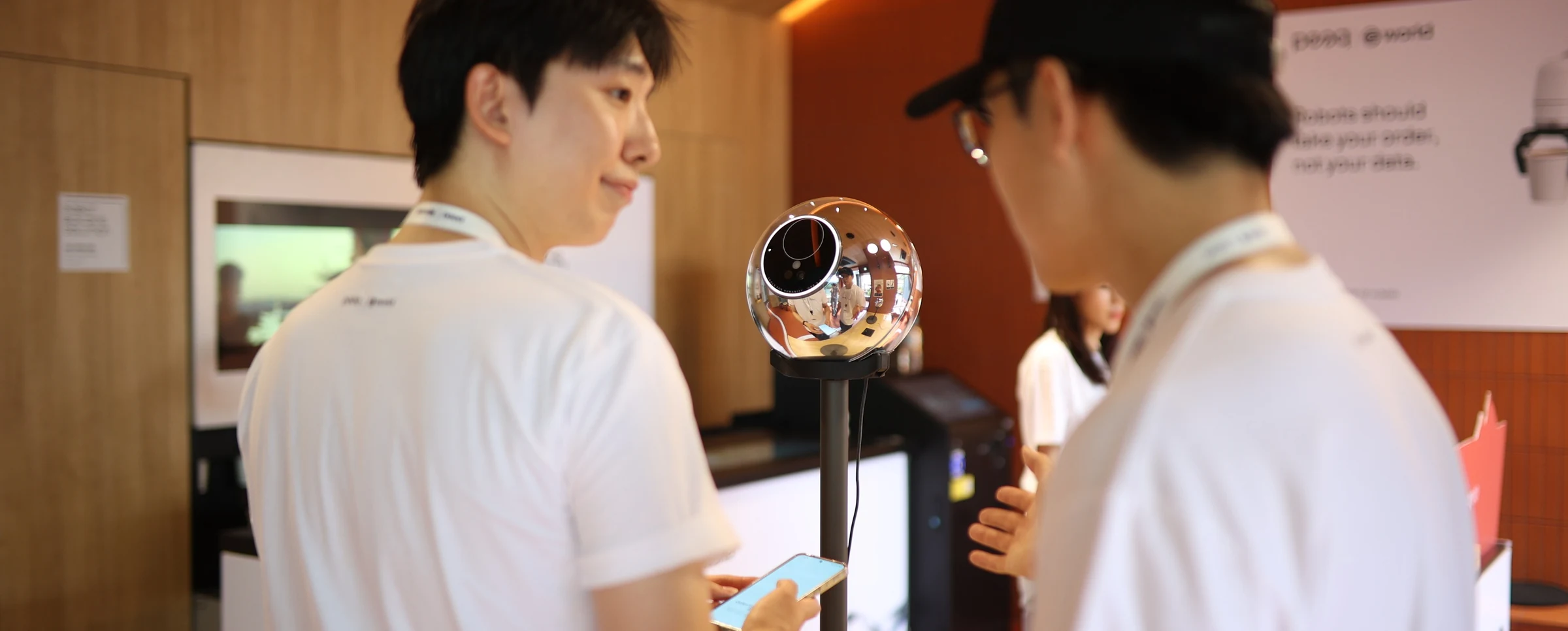 World × peaq — Visitors speaking beside a World Orb, KBW 2026